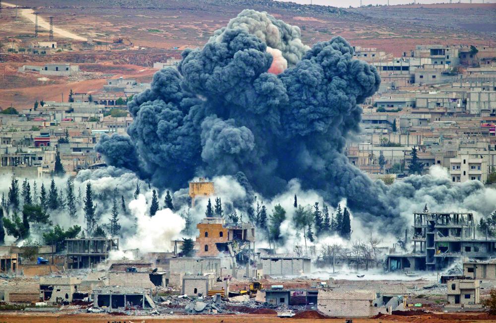 FILE - FILE - In this Nov. 17, 2014 file photo, smoke rises from the Syrian city of Kobani, following an airstrike by the U.S.-led coalition, seen from a hilltop outside Suruc, on the Turkey-Syria border. (AP Photo/Vadim Ghirda, File)