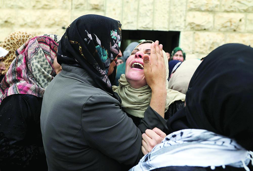 



فلسطينية تبكي بعد تشييع جثمان أحد أقاربها الذي قتل برصاص الجيش الإسرائيلي في الضفة أمس.  (أ.ف.ب)