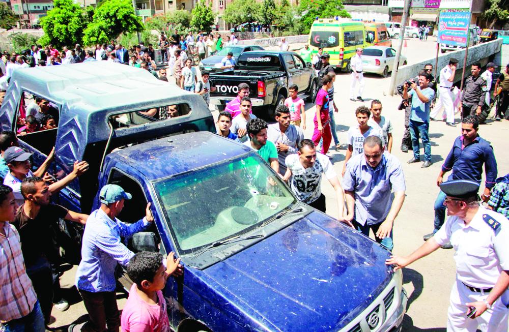 



دماء الضحايا في موقع الهجوم، ورجال أمن يعاينون آثار الاعتداء على سيارة الشرطة في الجيزة أمس. (أ. ف. ب)