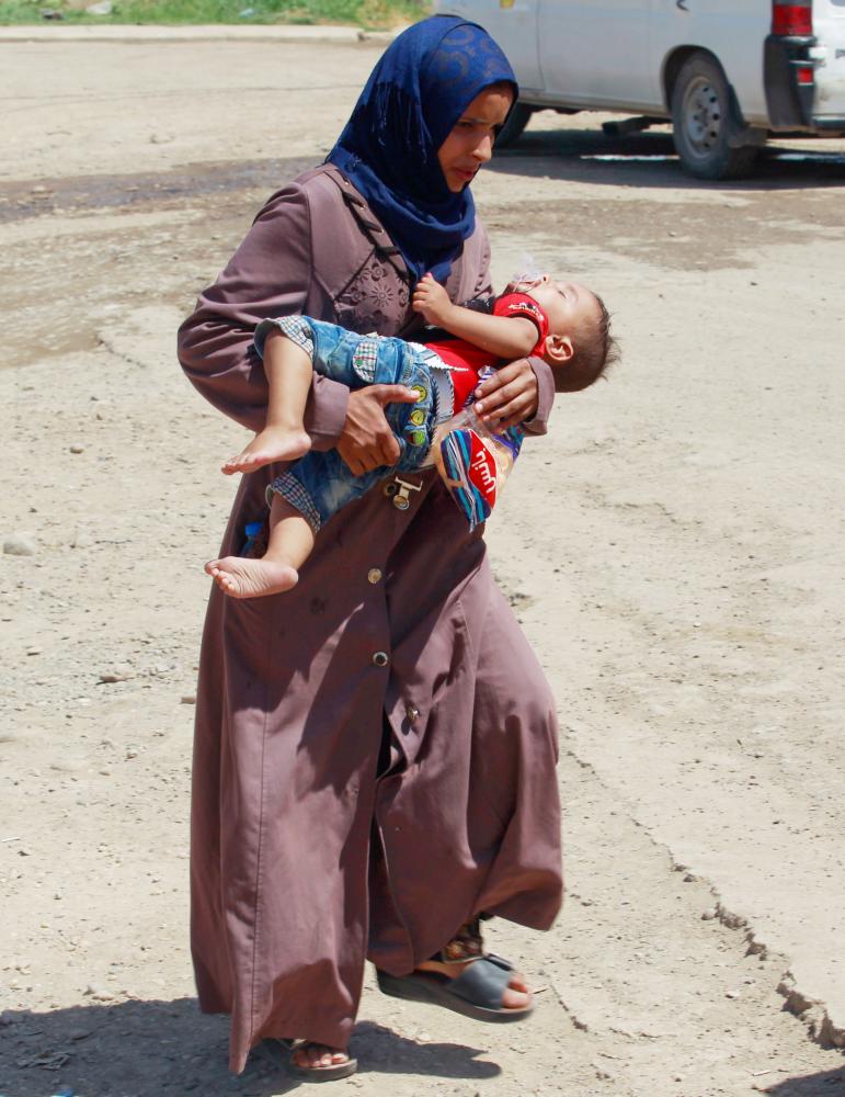 



عراقية تحمل طفلها أثناء هروبها من الموصل أمس الأول. (رويترز)