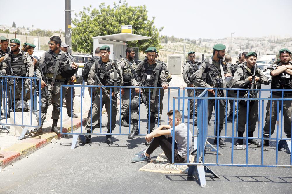 



فلسطيني يجلس بجانب نقطة تفتيش إسرائيلية في القدس انتظارا لصلاة الجمعة أمس. (أ. ف. ب)