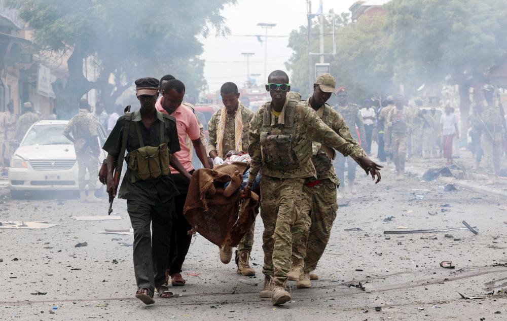 



صوماليون يحملون أحد ضحايا الانفجار. (أ. ف. ب)