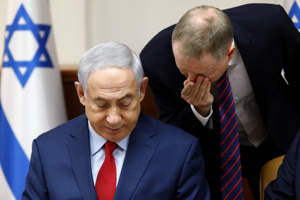 Israeli Prime Minister Benjamin Netanyahu, left, listens to an adviser at the weekly cabinet meeting at his office in Jerusalem on Sunday, Aug. 6, 2017. (Gali Tibbon, Pool via AP)