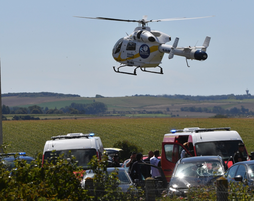 An helicopter of the emergency medical assistance SAMU arrives on the site after the police arrested a suspect on the A16 motorway, near Marquise, northern France, on August 9, 2017. Police gave chase to the vehicle on a motorway north of Paris, and shot and wounded the suspect, a man aged in his late 30s who was also arrested, sources involved in the manhunt said, speaking on condition of anonymity. French security forces launched a manhunt after a car rammed into anti-terrorism soldiers outside their barracks in a Paris suburb, injuring six. / AFP / Philippe HUGUEN
