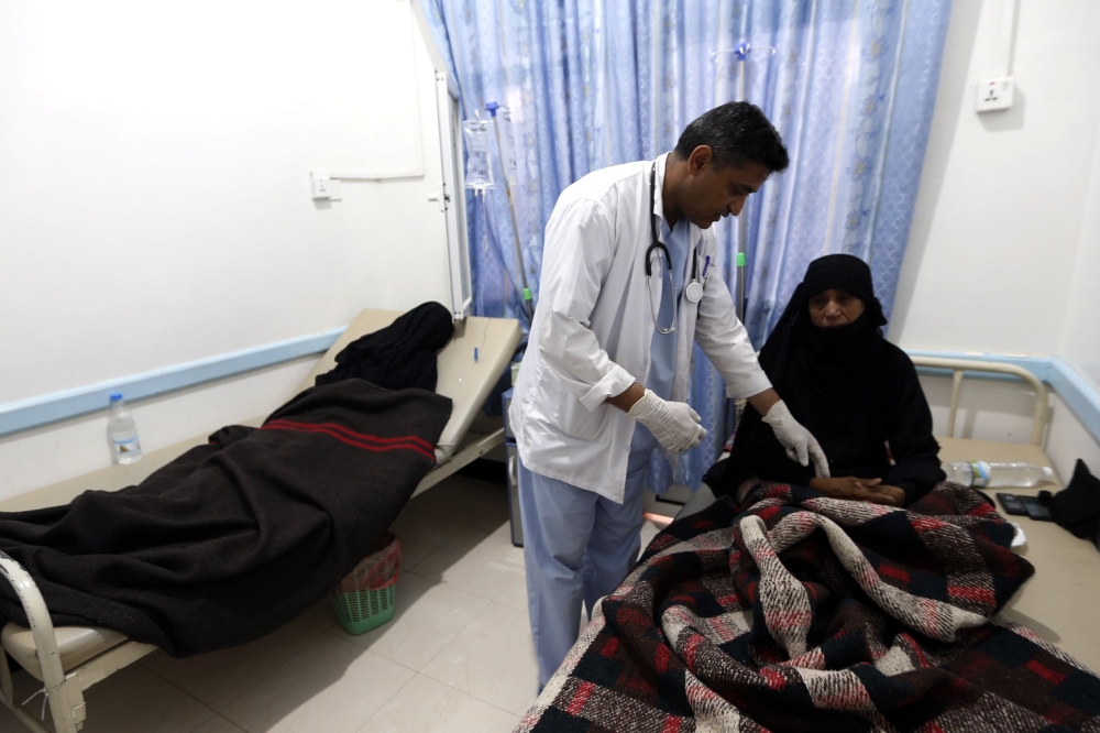 A Yemeni woman suspected of being infected with cholera, receives treatment at a hospital in the capital Sanaa, on August 12, 2017. A cholera outbreak has claimed the lives of some 2,000 Yemenis in less than four months. / AFP / Mohammed HUWAIS 