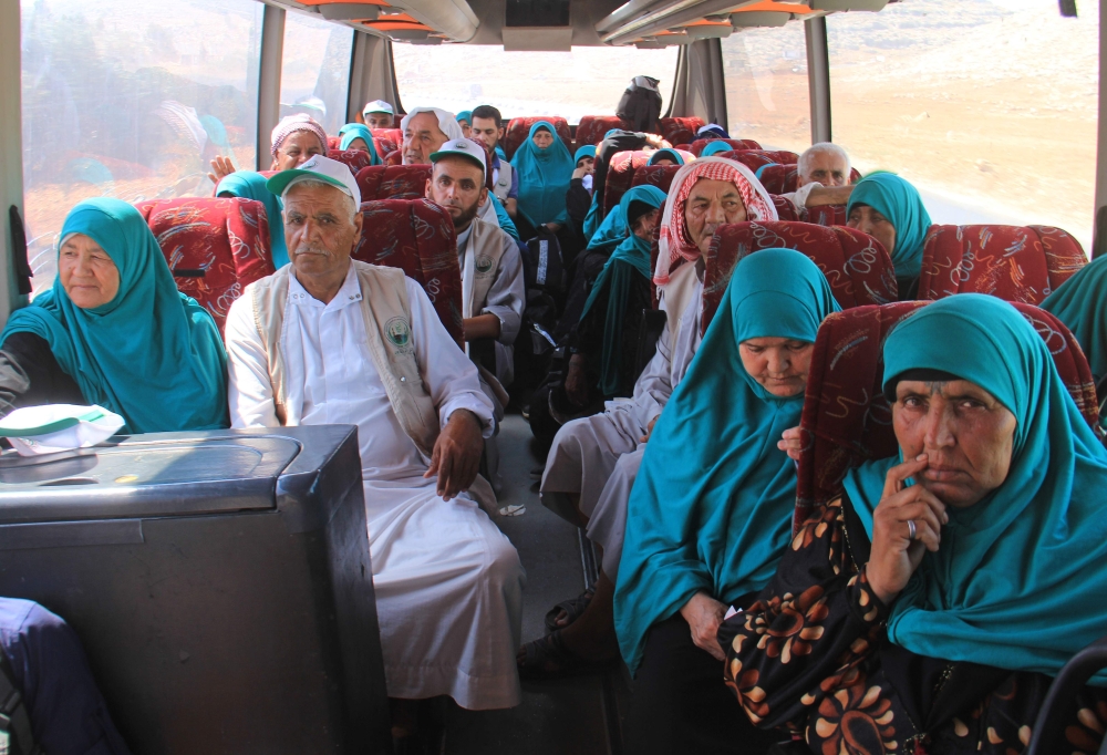 Syrians from the northwestern province of Idlib sit in a bus at the Bab al-Hawa border crossing on August 16, 2017 as they head to Turkey prior to travelling to Saudi Arabia for the annual Hajj pilgrimage. / AFP / Omar haj kadour
