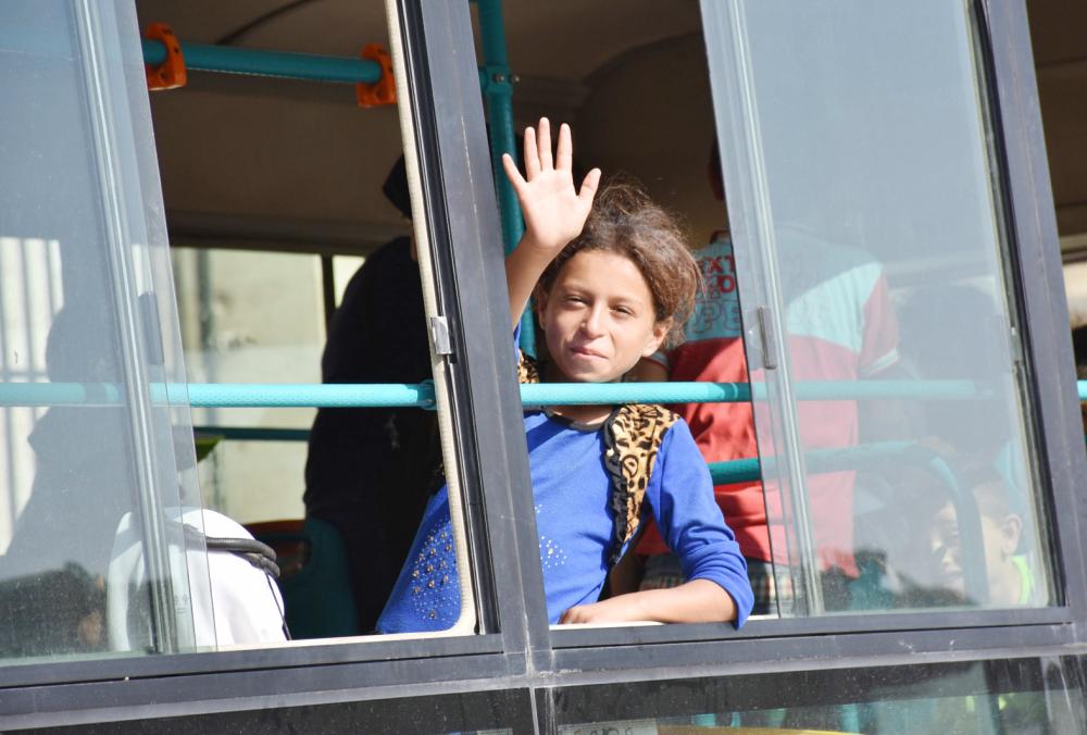 



فتاة سورية تلوح لأقاربها من نافذة حافلة تقل نازحين إلى معسكر في حلب أمس. (أ ف ب)