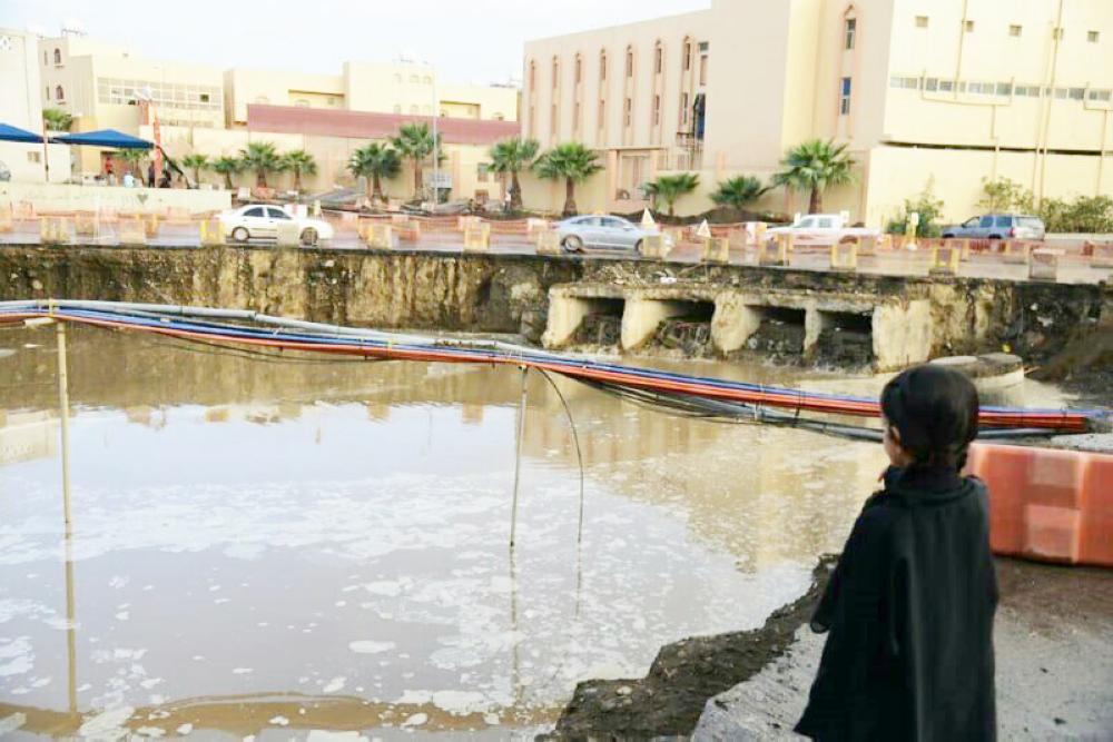 



طفله تقف على تجمع مياه الأمطار.