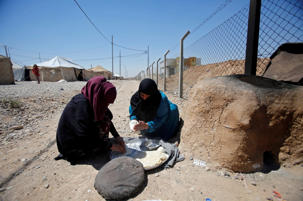 Displaced Iraqis from Talafar make bread in Salamya camp, east of Mosul, Iraq August 6, 2017. Picture taken August 6, 2017. REUTERS/Khalid Al-Mousily