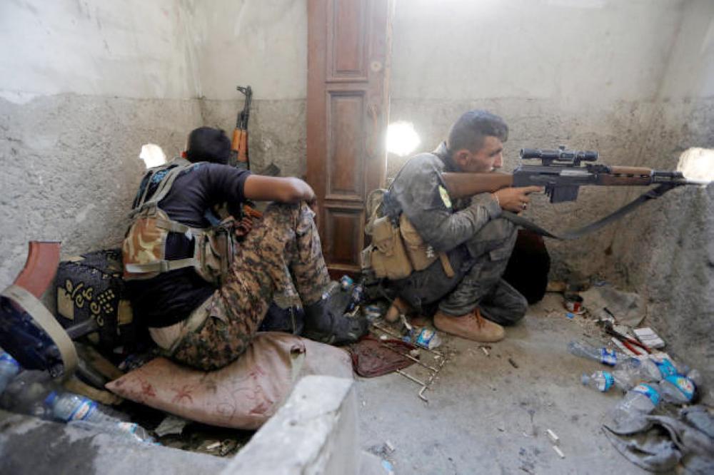  مقاتلان من القوات السورية الديموقراطية يقصفان مواقع لتنظيم 
 داعش في مدينة الرقة أمس. (رويترز)