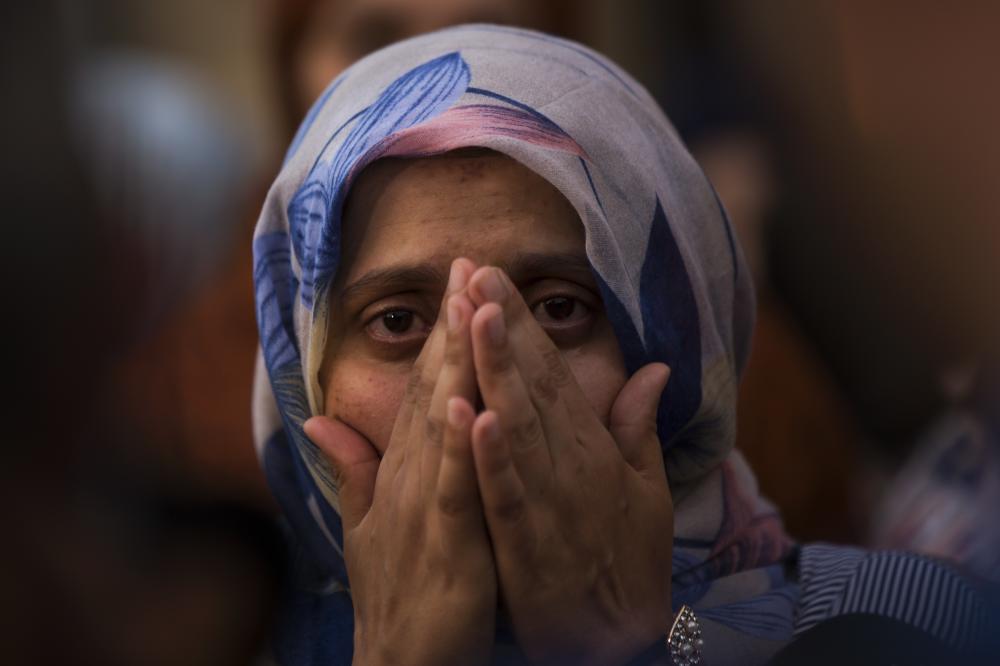 A woman weeps during a gathering of members of the local Muslim community along with relatives of young men believed responsible for the attacks in Barcelona and Cambrils to denounce terrorism and show their grief in Ripoll, north of Barcelona, Spain, Sunday Aug. 20, 2017. (AP Photo/Francisco Seco)