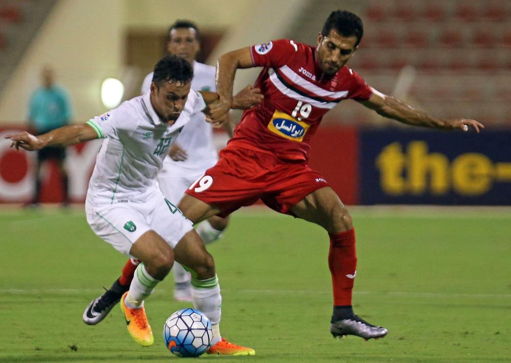 Saudi Arabia's Al-Ahli FC midfielder Leonardo De Sousa (L) vies for the ball against Iranian Persepolis FC's Vahid Amiri during their AFC Champions League qualifying football match at the Sultan Qaboos Sports Complex in Muscat on August 22, 2017. / AFP / MOHAMMED MAHJOUB
