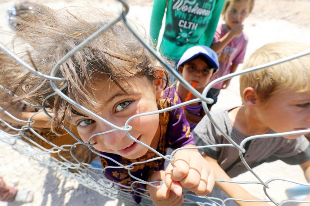



أطفال سوريون نازحون من الرقة في مخيم عين عيسى، وفي الإطار طفل يروي ظمأه أمس الأول. (أ ف ب)