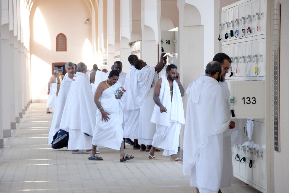 زوار يضعون حوائجهم في صناديق الأمانات في مسجد الميقات بالمدينة.