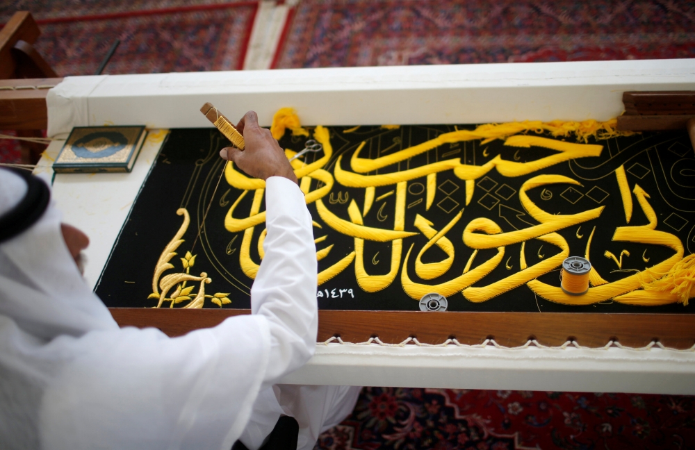 A man embroiders the Kiswa, a silk cloth covering the Holy Kaaba, ahead of the annual Haj pilgrimage, at a factory in the holy city of Makkah on Sunday. — Reuters