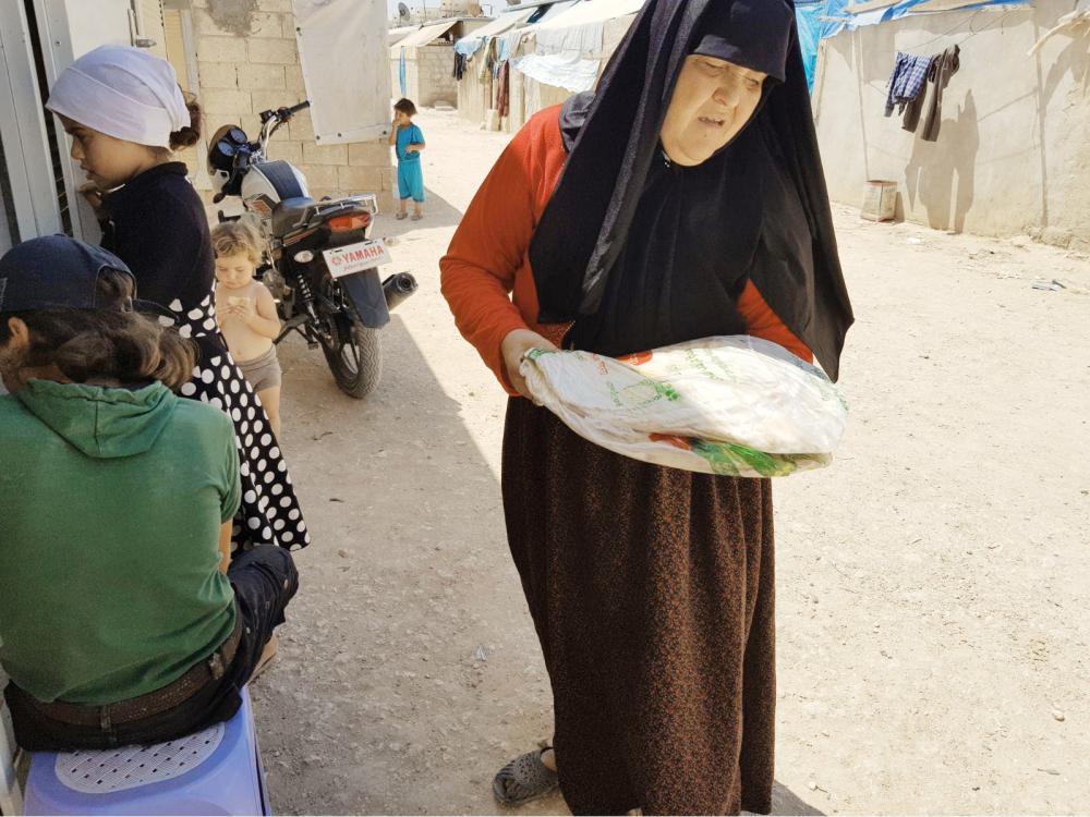 



مسنة سورية تحمل حصتها من الخبز.