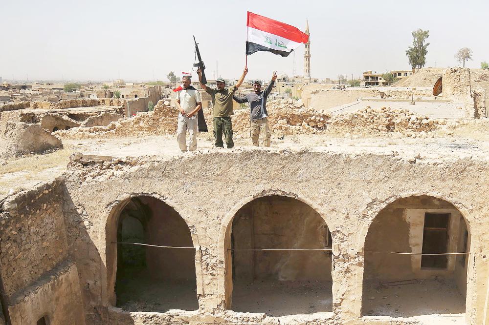 



مقاتلون من الحشد الشعبي العراقي يرفعون علم بلادهم على قلعة تلعفر التاريخية، بعد استعادة المدينة من تنظيم داعش أمس. (أ. ف. ب)