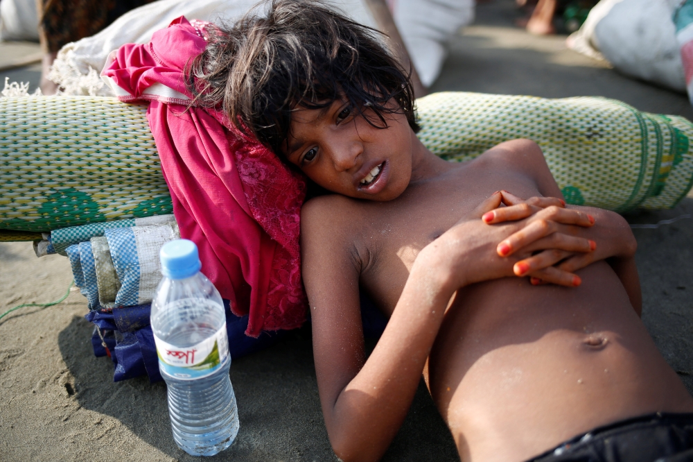 A Rohingya refugee girl lies on the ground as she suffers from dehydration after crossing the Bangladesh-Myanmar border by boat through the Bay of Bengal in Teknaf, Bangladesh, September 5, 2017. REUTERS/Mohammad Ponir Hossain