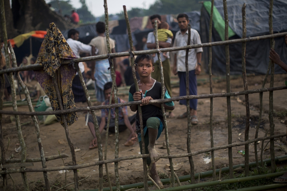 A Rohingya child, newly arrived from Myanmmar to the Bangladesh side of the border, stands by a wooden fence at Kutupalong refugee camp in Ukhia, Tuesday, Sept. 5, 2017. Bangladesh, one of the world's poorest countries, was already sheltering some 100,000 Rohingya refugees before another 123,000 flooded in after Aug. 25, according to the U.N. refugee agency's latest estimate on Tuesday. (AP Photo/Bernat Armangue)