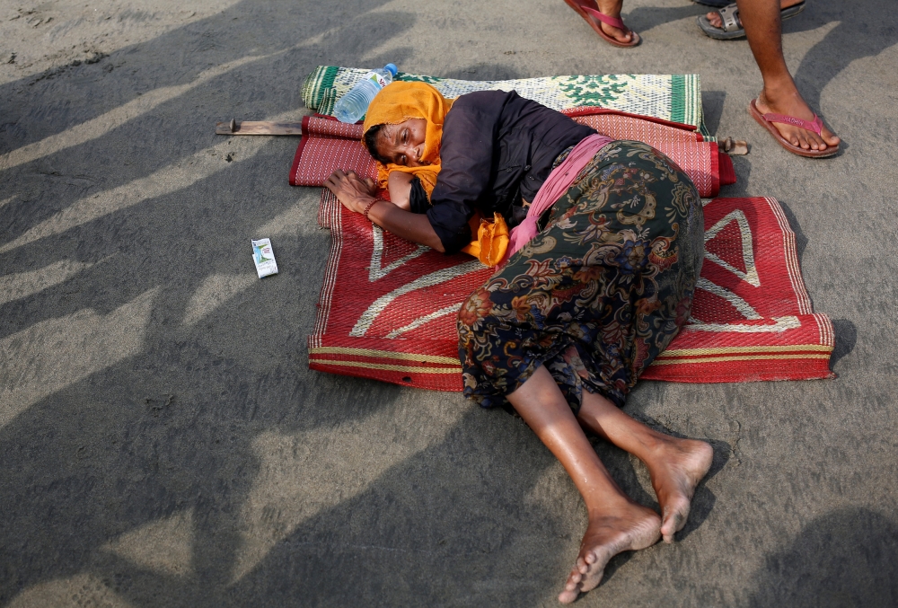 An old Rohingya refugee woman lies on the shore as she suffers from dehydration after crossing the Bangladesh-Myanmar border by boat through the Bay of Bengal in Teknaf, Bangladesh, September 5, 2017. REUTERS/Mohammad Ponir Hossain