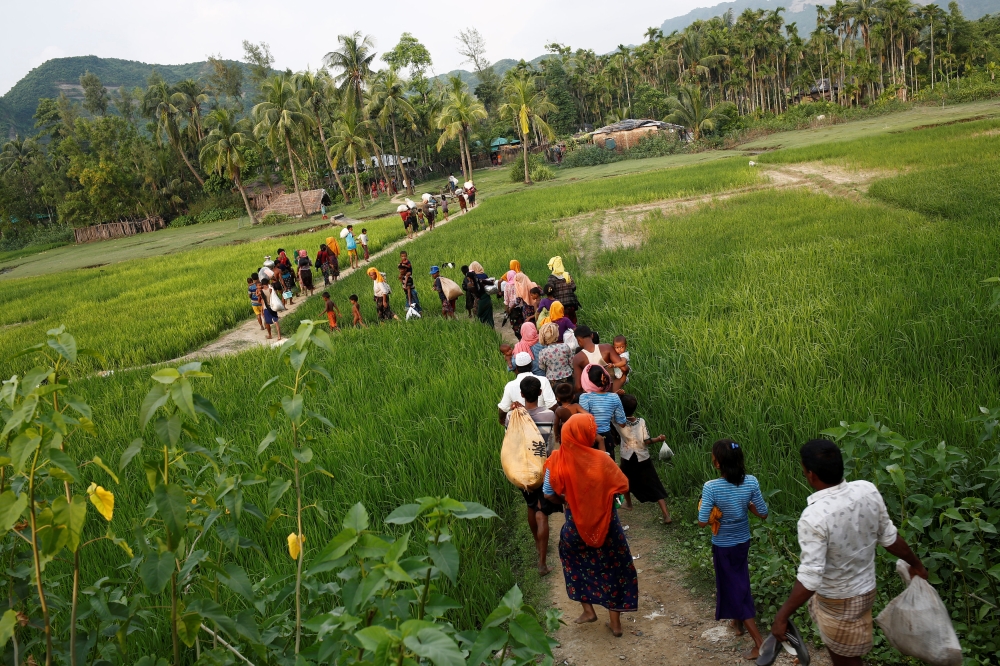 Rohingya refugees walk to the nearest village after crossing the Bangladesh-Myanmar border by boat through the Bay of Bengal in Teknaf, Bangladesh, September 5, 2017. REUTERS/Mohammad Ponir Hossain