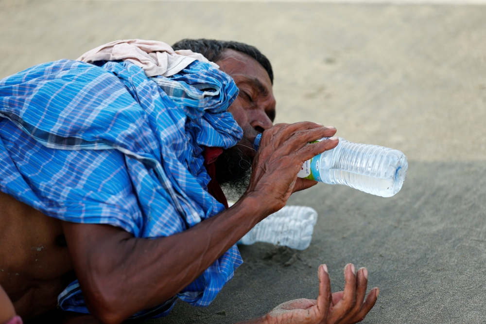 A Rohingya refugee man drinks water after crossing the Bangladesh-Myanmar border by boat through the Bay of Bengal in Teknaf, Bangladesh, September 5, 2017. REUTERS/Mohammad Ponir Hossain