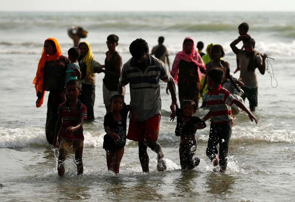 Rohingya refugees walk to the shore after crossing the Bangladesh-Myanmar border by boat through the Bay of Bengal in Teknaf, Bangladesh, September 5, 2017. REUTERS/Mohammad Ponir Hossain