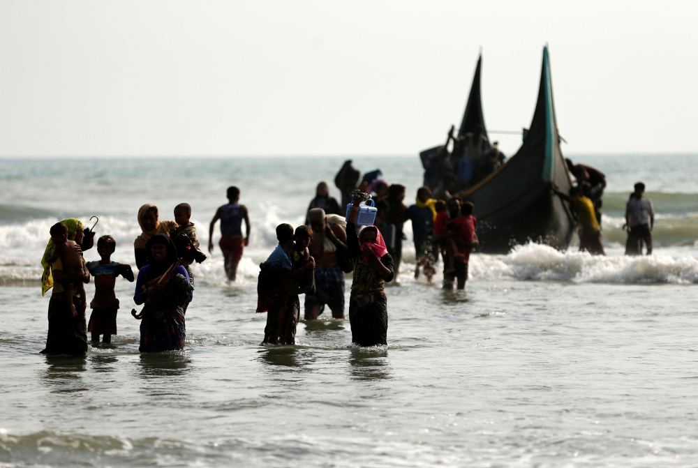 Rohingya refugees walk to the shore after crossing the Bangladesh-Myanmar border by boat through the Bay of Bengal in Teknaf, Bangladesh, September 5, 2017. REUTERS/Mohammad Ponir Hossain