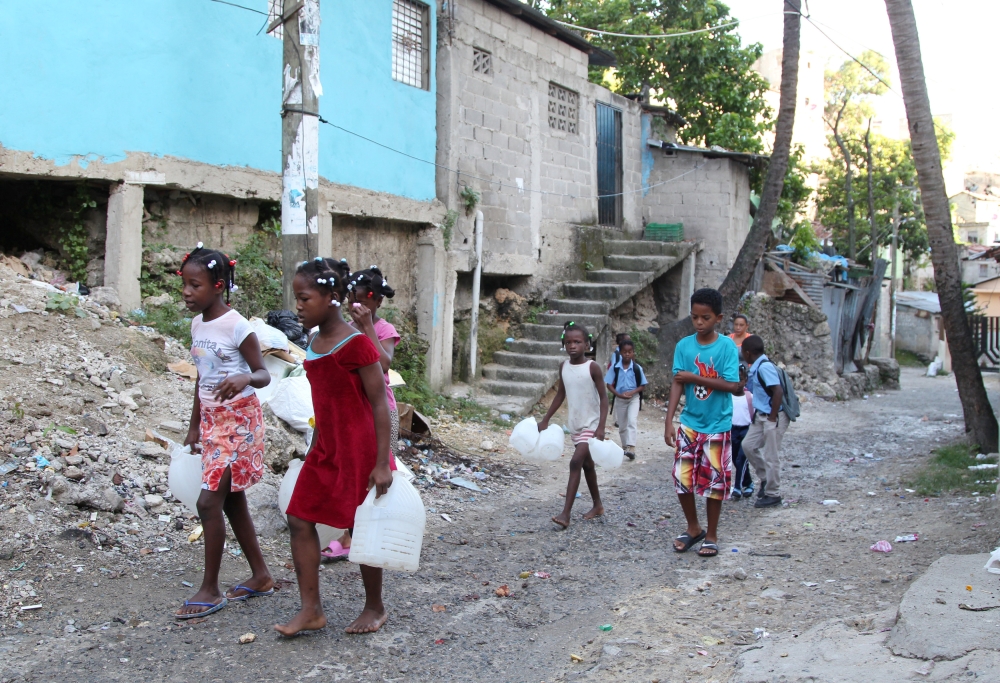 Children in a low-income neighborhood carry containers for water as Hurricane Irma slammed across islands in the northern Caribbean on Wednesday, in Santo Domingo, Dominican Republic September 6, 2017.  REUTERS/Ricardo Rojas