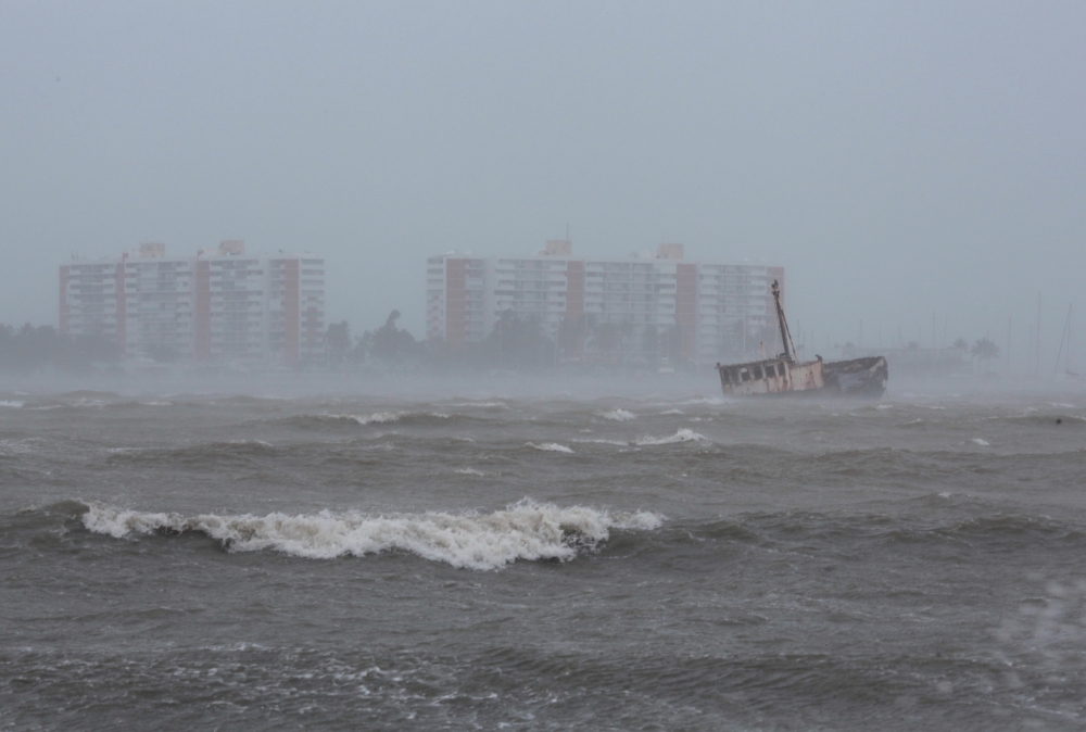 Waves battle a stranded ship as Hurricane Irma slammed across islands in the northern Caribbean on Wednesday, in Fajardo, Puerto Rico September 6, 2017.  REUTERS/Alvin Baez