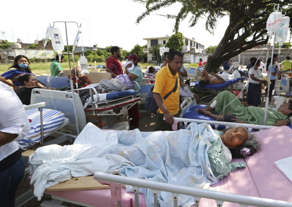 Evacuated patients lie on their hospital beds shaded by a tree, in the aftermath of a massive earthquake in Juchitan, Oaxaca state, Mexico, Friday, Sept. 8, 2017. One of the most powerful earthquakes ever to strike Mexico hit off its southern Pacific coast, causing dozens of fatalities, toppling houses, government offices and businesses. (AP Photo/Luis Alberto Cruz)