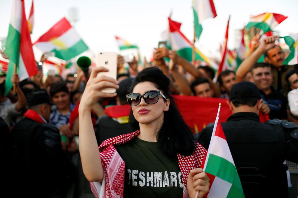 A Kurdish woman takes a selfie to show support for the upcoming September 25th independence referendum in Erbil, Iraq September 22, 2017. REUTERS/Ahmed Jadallah
