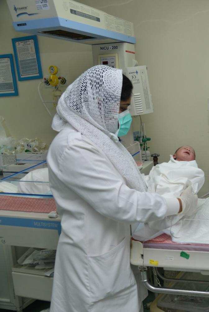 ممرضة تحمل اول مولودة في جدة أمس «عكاظ» 