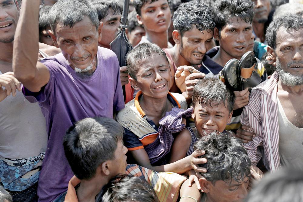 بكاء وزحام شديد في مخيم لاجئي الروهينغا في بنغلاديش أمس. (رويترز)