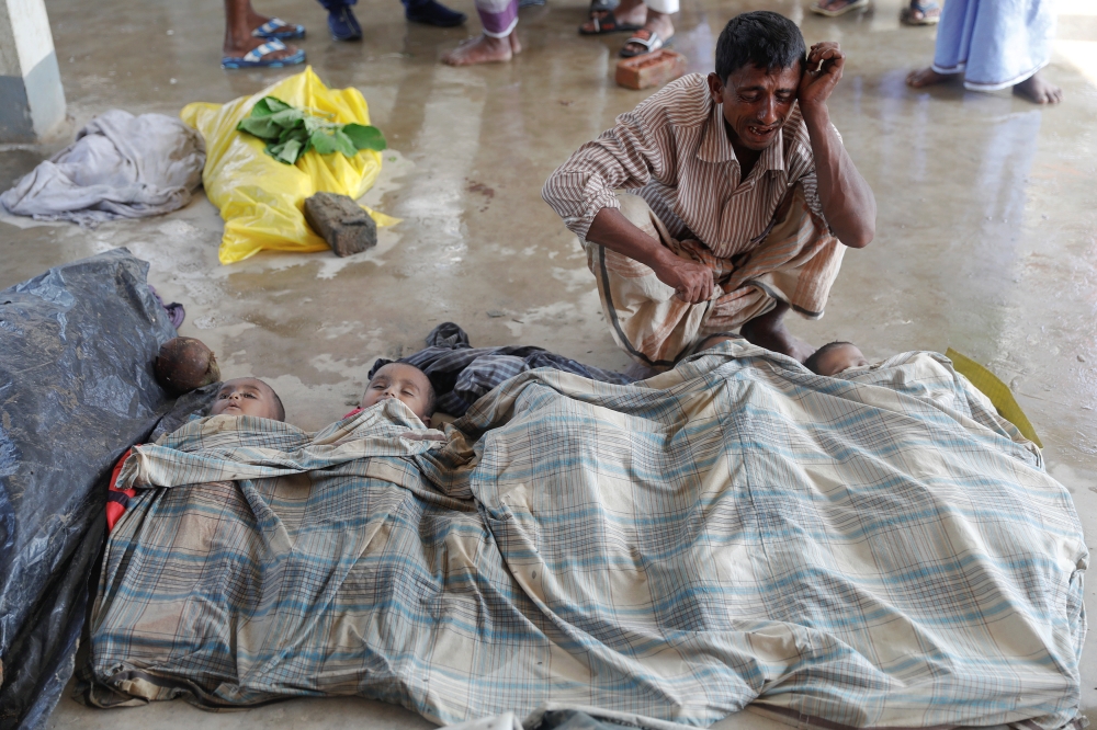 ATTENTION EDITORS - VISUAL COVERAGE OF SCENES OF DEATH Shuna Miya cries over bodies of his daughters before their bodies are taken for the funeral just behind Inani Beach near Cox's Bazar, Bangladesh September 29, 2017. Miya, whose family was on the boat that capsized, just off the shore of Bangladesh, as he was fleeing Myanmar, lost three daughters in the accident. His other three children and wife survived. REUTERS/Damir Sagolj TEMPLATE OUT