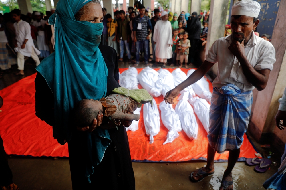 ATTENTION EDITORS - VISUAL COVERAGE OF SCENES OF DEATH The body of one of Rohingya refugee children who died after their boat capsized as they were fleeing from Myanmar, is prepared for the funeral just behind Inani Beach near Cox's Bazar, Bangladesh September 29, 2017. REUTERS/Damir Sagolj TEMPLATE OUT