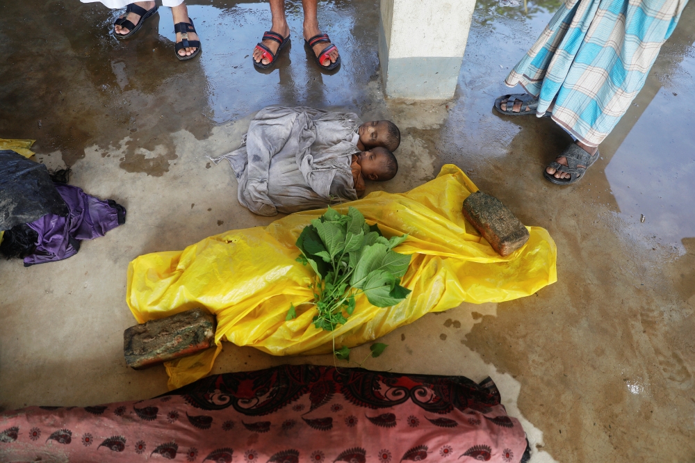 ATTENTION EDITORS - VISUAL COVERAGE OF SCENES OF DEATH People gather around bodies of Rohingya refugee children who died after their boat capsized as they were fleeing Myanmar, before the mass funeral for victims just behind Inani Beach near Cox's Bazar, Bangladesh September 29, 2017. REUTERS/Damir Sagolj TEMPLATE OUT