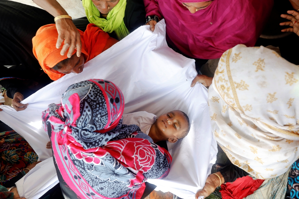 ATTENTION EDITORS - VISUAL COVERAGE OF SCENES OF INJURY OR DEATH The body of one of the Rohingya refugee children who died after their boat capsized, as they were fleeing Myanmar, is prepared for the funeral just behind Inani Beach near Cox's Bazar, Bangladesh September 29, 2017. REUTERS/Damir Sagolj TEMPLATE OUT