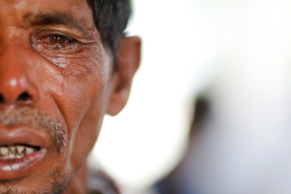 Lalu Miya cries over the bodies of his wife and children, who died after a boat with Rohingya refugees capsized as they fled from Myanmar, before their bodies were taken for the funeral just behind Inani beach near Cox's Bazar, Bangladesh September 29, 2017. Lalu Miya, whose family was on the boat that capsized just off the shore of Bangladesh, survived but three of his children and wife died in the accident. Two other of his children remain missing. REUTERS/Damir Sagolj