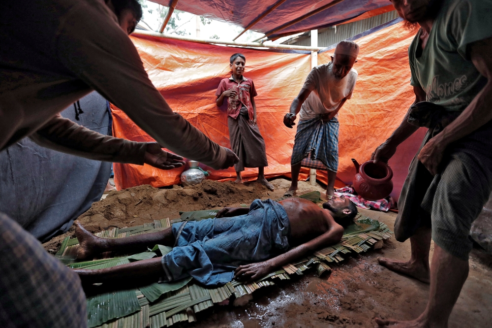 ATTENTION EDITORS - VISUAL COVERAGE OF SCENES OF DEATH AND INJURY Rohingya refugees bathe the remains of a family member, whose family says he succumbed to injuries inflicted by the Myanmar Army before their arrival, in Cox's Bazar, Bangladesh, September 29, 2017. REUTERS/Cathal McNaughton TEMPLATE OUT