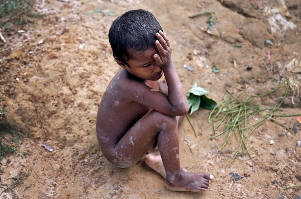 A Rohingya refugee child cries as he sits on the ground in Cox's Bazar, Bangladesh, September 29, 2017. REUTERS/Cathal McNaughton