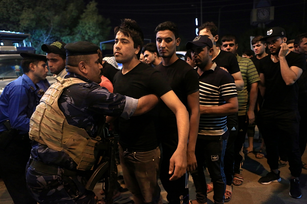 Iraqi police search Shiite faithful as they attend a Muharram procession in Basra, 340 miles (550 kilometers) southeast of Baghdad, Iraq, Thursday, Sept. 28, 2017. Security forces take extra security measures during Muharram, a month of mourning in remembrance of the martyrdom of Imam Hussein, the grandson of Prophet Mohammed. (AP Photo/Nabil al-Jurani)