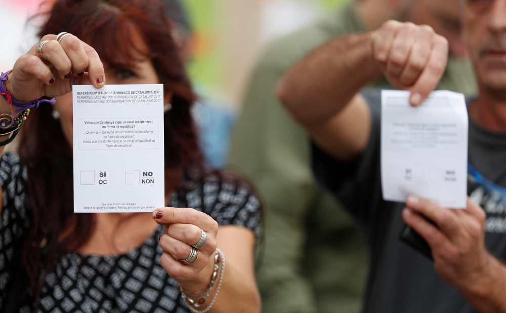 People show ballots tbefore the banned October 1 independence referendum, in Barcelona, Spain, September 30, 2017. REUTERS/Yves Herman