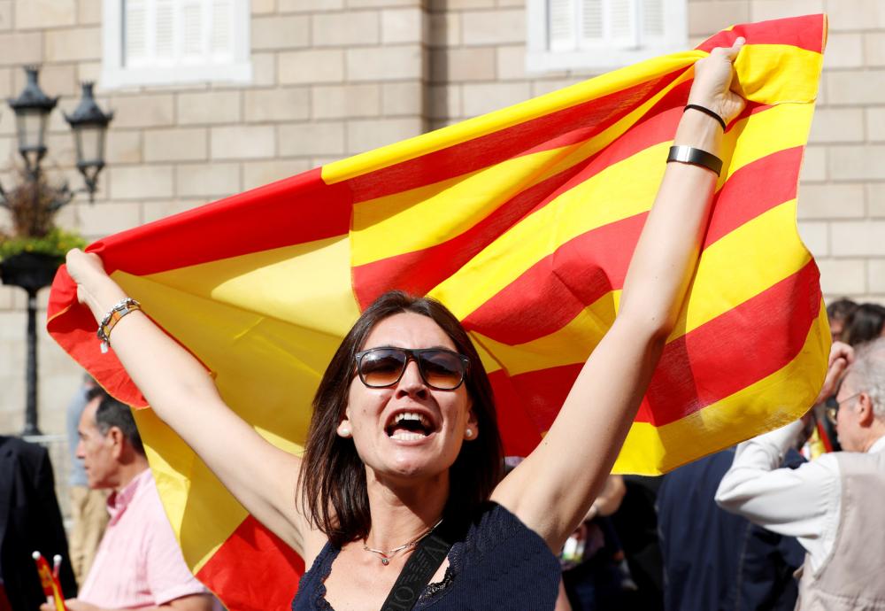 A woman holds up a Spanish flag during a demonstration in favor of a unified Spain a day before the banned October 1 independence referendum, in Barcelona, Spain, September 30, 2017. REUTERS/Yves Herman