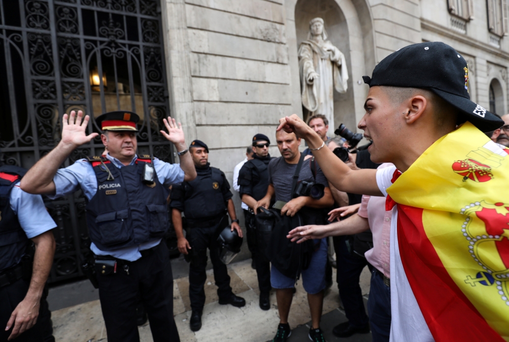 A demonstrator shouts at a Mosso d'Esquadra, Catalan regional policeman, in front of city hall during a demonstration in favor of a unified Spain a day before the banned October 1 independence referendum, in Barcelona, Spain, September 30, 2017. REUTERS/Susana Vera