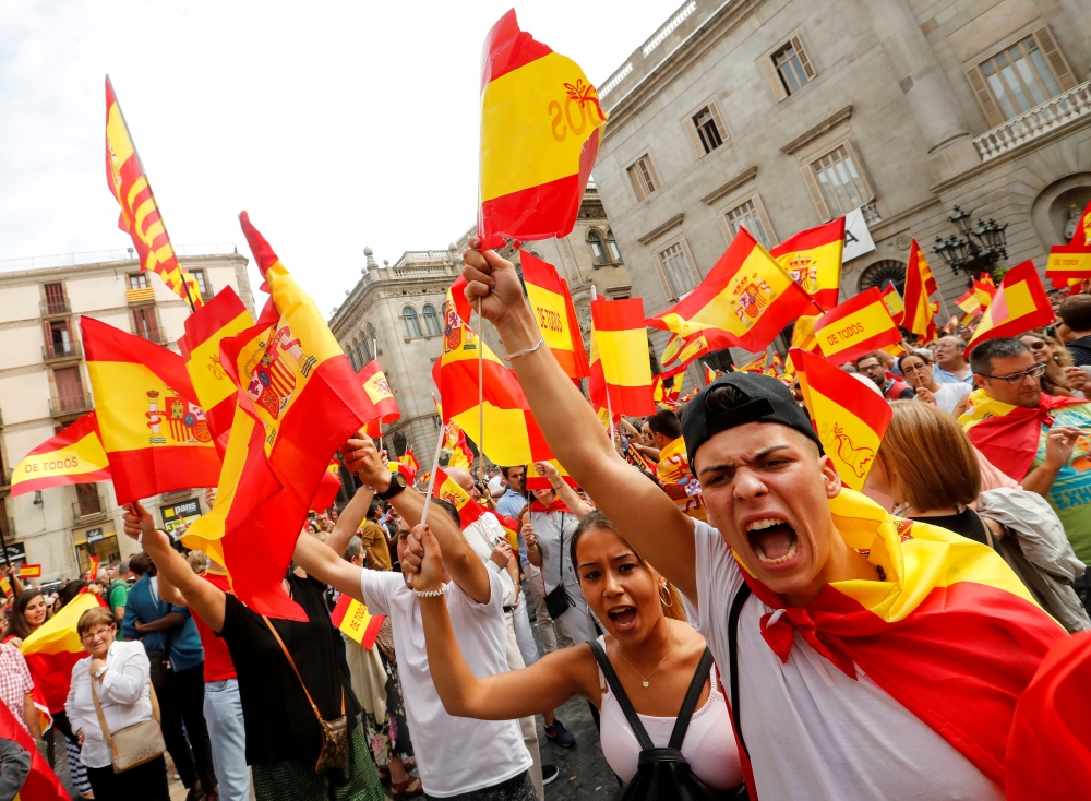 People shout and hold up Spanish flags during a demonstration in favor of a unified Spain a day before the banned October 1 independence referendum, in Barcelona, Spain, September 30, 2017. REUTERS/Yves Herman     TPX IMAGES OF THE DAY