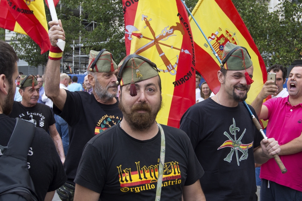 Protesters in legionnaires uniforms participate as thousands packed the central Cibeles square in Madrid, Spain, Saturday, Sept. 30, 2017. Thousands of pro-Spanish unity supporters donning Spanish flags have rallied in a central Madrid plaza to protest the Catalan regional government's drive to separate from Spain. Message on t-shirt reads: 'The Legion, Patriotic Pride'. (AP Photo/Paul White)