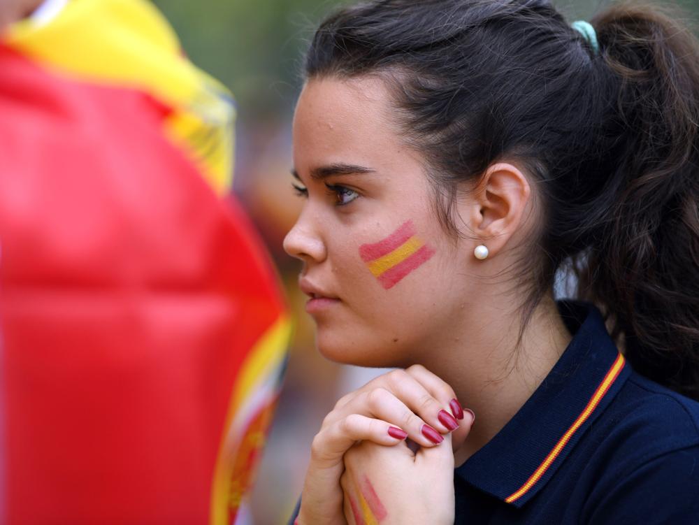 A girl sporting a Spanish flag painted on her face takes part in a demonstration against independence of Catalonia called by DENAES foundation for the Spanish Nation Defence on September 30, 2017 in Madrid.  Catalan separatists showed determination today to press ahead with an independence referendum banned by Madrid, occupying dozens of schools designated as polling stations to stop police from closing them down. / AFP / GABRIEL BOUYS                     
