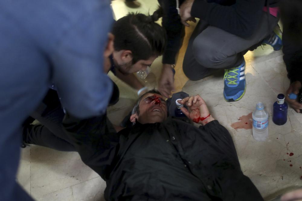 A protester is attended after being hit by a rubber bullet shot by Spanish National Police near the Ramon Llull school assigned to be a polling station by the Catalan government in Barcelona, Spain, early Sunday, 1 Oct. 2017. The Spanish government and its security forces are trying to prevent voting in the independence referendum, which is backed by Catalan regional authorities. Spanish officials had said force wouldn't be used, but that voting wouldn't be allowed. (AP Photo/Manu Brabo)