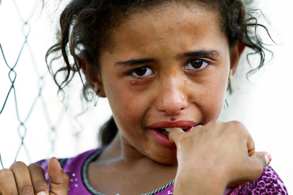 طفلة عراقية تبكي عقب هروبها من مدينة الحويجة شمال بغداد إلى مخيم للاجئين أمس الأول. (أ ف ب)